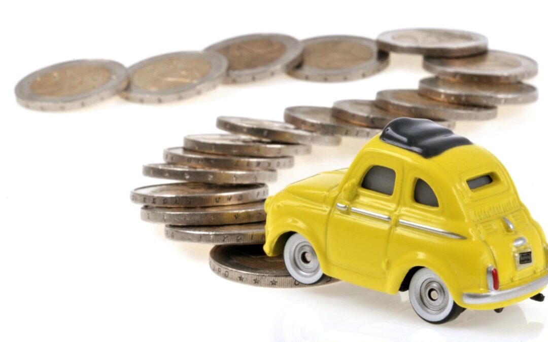 Capital and revenue expenses: a photo of a yellow toy fiat 500 driving on a road made of coins.
