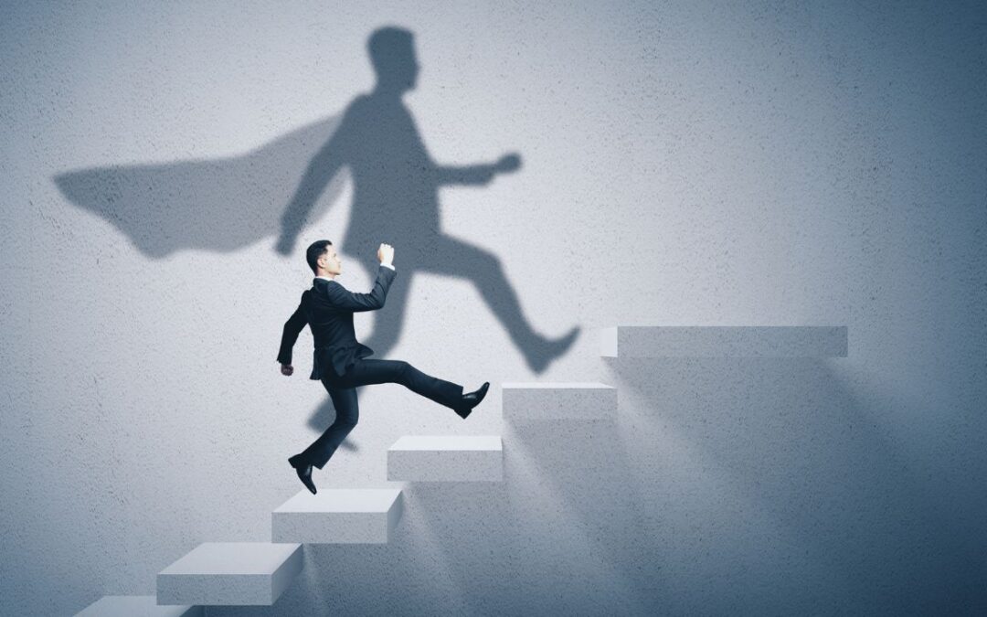 Self-belief in business: an image of a person in a business suit climbing stairs. His shadow is one of a mane with a cape - like a superhero.