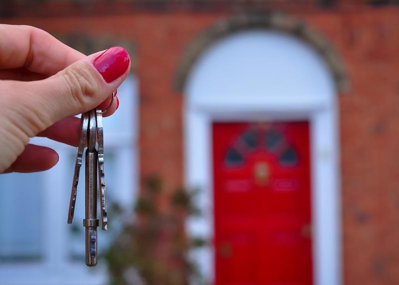 Keys being held up to a red door